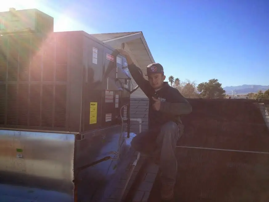 HVAC technician performing Air Duct Cleaning on a rooftop unit in Stonecrest